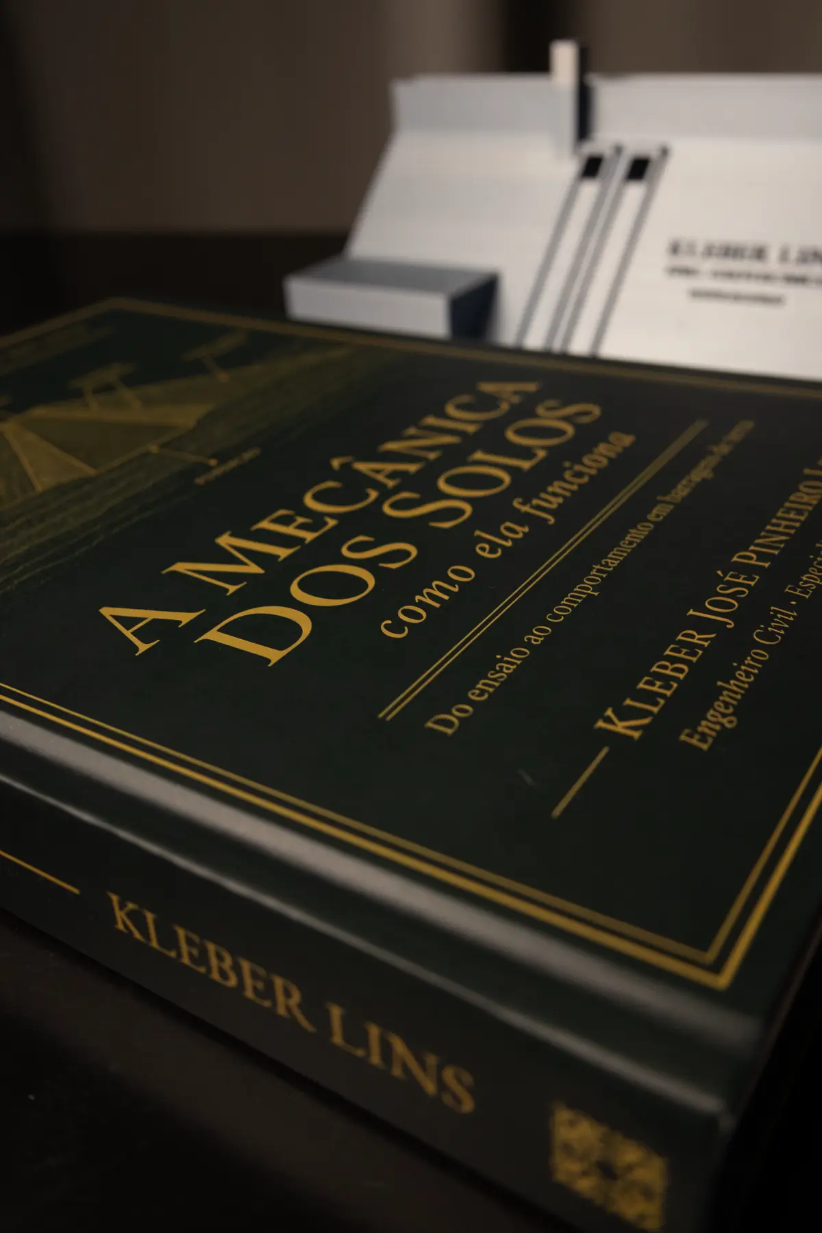 Livro em close na mesa de trabalho, com o nome do autor gravado na lombada