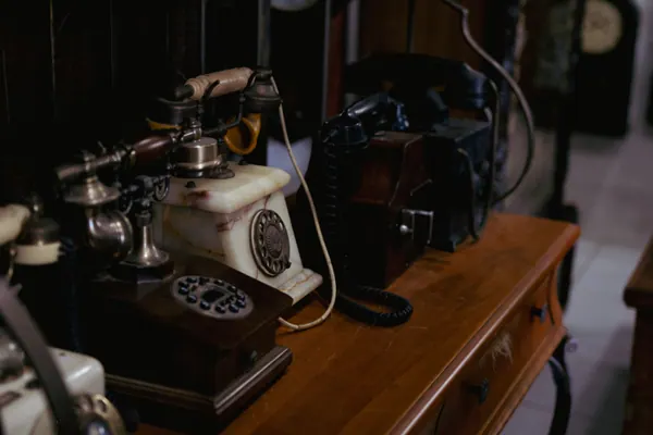 Telefones antigos de disco sobre um aparador de madeira