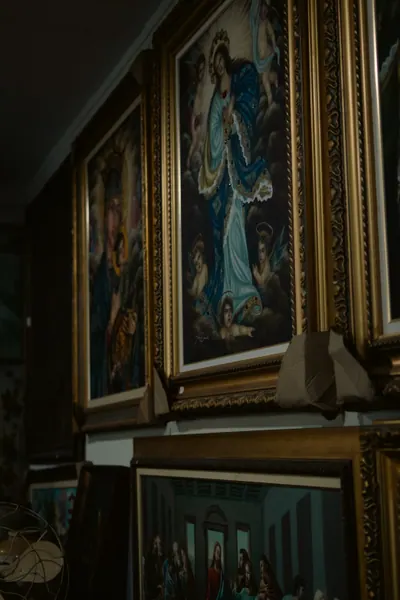 Quadros religiosos de moldura dourada encostados na parede
