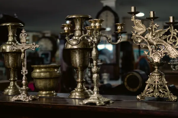 Castiçais de metal e um crucifixo sobre o aparador