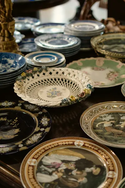Pilhas de pratos decorativos de porcelana, alguns pintados à mão