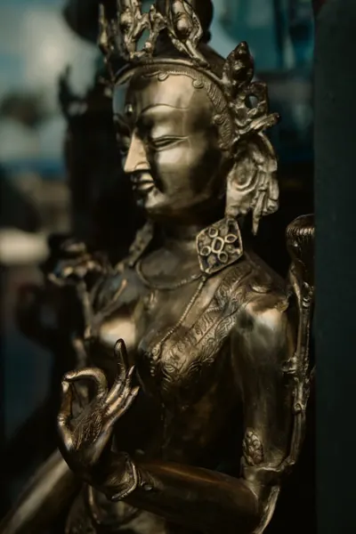 A estátua de bronze de perfil, contra o azulejo azul