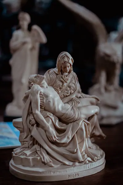 Réplica da Pietà em mármore branco, sobre a mesa de madeira
