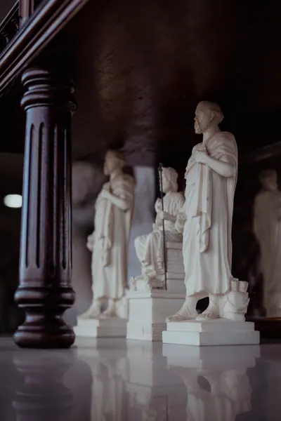 As mesmas estatuetas, com a coluna de madeira em primeiro plano