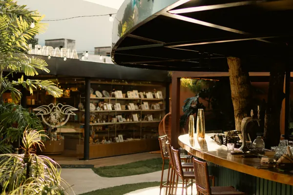 A livraria da casa, com prateleiras iluminadas e banquetas altas no balcão