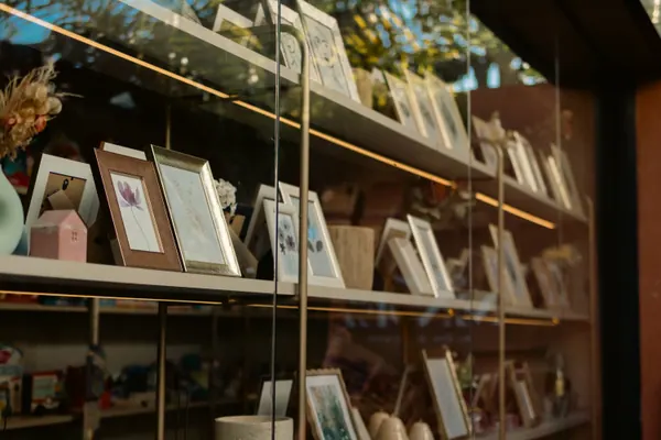Prateleira de quadros e objetos atrás do vidro da livraria