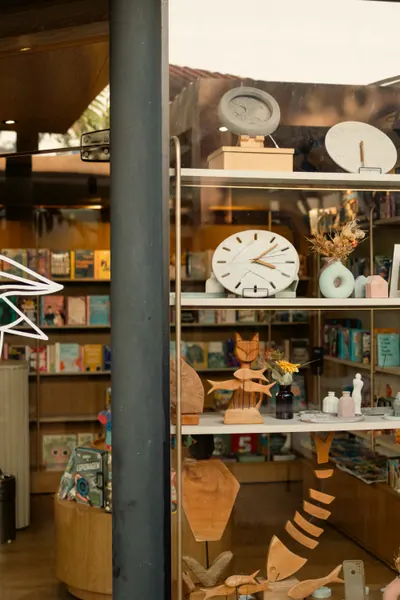 Vitrine com relógios de parede, livros e brinquedos de madeira
